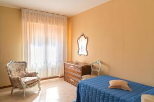 a bedroom with a bed and a dresser and a window at Casa Italia - Appartamento con giardino e cortile privato in Sinalunga