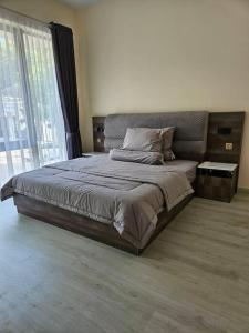 a large bed in a bedroom with a large window at 4BR Private Villa with Pool in the Heart of city in Batu Ampar