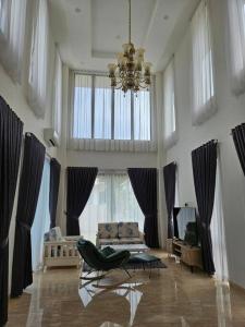 sala de estar amplia con lámpara de araña y sofá en 4BR Private Villa with Pool in the Heart of city en Batu Ampar
