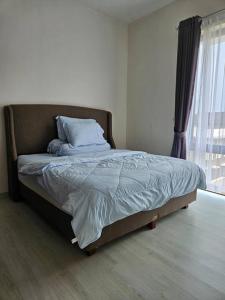 a bed sitting in a bedroom with a window at 4BR Private Villa with Pool in the Heart of city in Batu Ampar