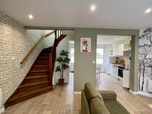 a living room with a couch and a staircase at Le Naturescence, calme, idéal visite Côte d'Opale in Saint-Martin-Boulogne