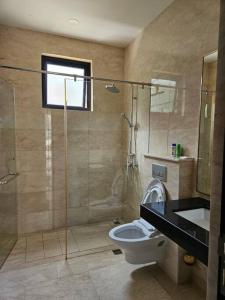 a bathroom with a shower and a toilet and a sink at 4BR Private Villa with Pool in the Heart of city in Batu Ampar