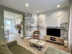 ein Wohnzimmer mit Flachbildfernseher und Couch in der Unterkunft Naturescence in Saint-Martin-Boulogne