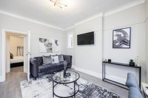 ein Wohnzimmer mit einem Sofa und einem TV in der Unterkunft Modern Apartment - Perfect Location - by Luxiety stays serviced accommodation Southend on Sea in Southend-on-Sea