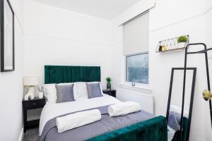 1 dormitorio con 1 cama con cabecero verde en Modern Apartment - Perfect Location - by Luxiety stays serviced accommodation Southend on Sea, en Southend-on-Sea