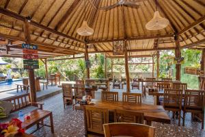 um restaurante vazio com mesas e cadeiras de madeira em Bagus Dream Beach Villa Lembongan em Nusa Lembongan