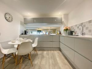 a kitchen with a table and chairs and a clock at Chic Clifton Home – inviting décor & outdoor space in Bristol