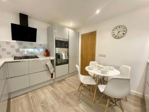 una cocina con mesa y sillas y un reloj en la pared en Chic Clifton Home – inviting décor & outdoor space en Bristol