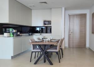a kitchen with a wooden table and chairs at Farhan Tower in Juffair