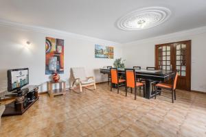 a living room with a black piano and orange chairs at Charming and Calm House - 5 minutes from the Beach by car in Vila Nova de Gaia