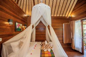 um quarto com uma cama e uma rede mosquiteira em Bagus Dream Beach Villa Lembongan em Nusa Lembongan