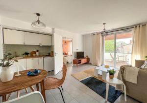 cocina y sala de estar con mesa en Confortable T2 pour 4 voyageurs, parking privé et terrasse, en Toulouse