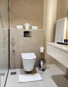 a bathroom with a toilet and a glass shower at Farhan Tower in Juffair