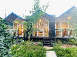 mały dom z niebieskim dachem i schodami w obiekcie Nhà Trong Sương Đà Lạt w mieście Da Lat