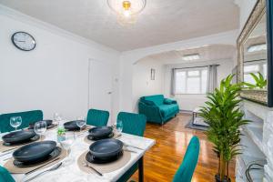 a dining room with a table and green chairs at 3 bed Gorgeous house AbbeyWood in Abbey Wood