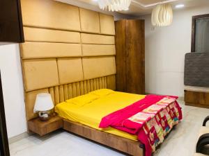 um quarto com uma cama com um cobertor amarelo em BLUE SKY VILLA em Lonavala