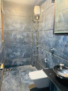a bathroom with a toilet and a sink at BLUE SKY VILLA in Lonavala