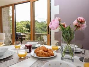 a table with croissants and flowers in a vase at The Cider House in Saltash