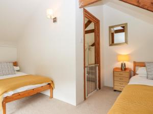 a bedroom with two beds and a mirror at The Cider House in Saltash