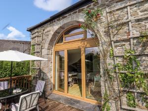 a stone house with a glass door and a patio at The Cider House in Saltash