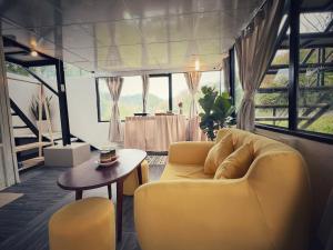 sala de estar con sofá amarillo y mesa en Nhà Trong Sương Đà Lạt en Dalat