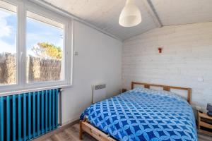 ein Schlafzimmer mit einem Bett und einem Fenster in der Unterkunft Appartement 10 pers à 50m plage in Barbâtre