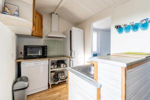 eine kleine Küche mit Spüle und Mikrowelle in der Unterkunft Appartement 10 pers à 50m plage in Barbâtre + 11 Fotos