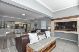 a living room with a couch and a fireplace at Apartment 6 in Yzerfontein