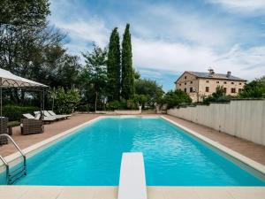 ein großer blauer Pool vor einem Haus in der Unterkunft Villa Maria by VacaVilla in Appignano