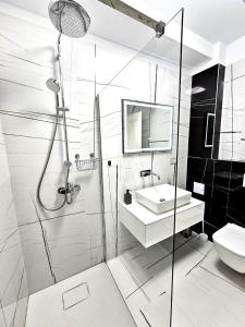 La salle de bains est pourvue d'une douche, d'un lavabo et de toilettes. dans l'établissement Luxury Apartment, à Bucarest