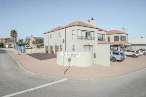 a white building on a street with a parking lot at Apartment 6 in Yzerfontein