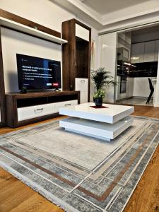 ein Wohnzimmer mit einem weißen Tisch und einem TV in der Unterkunft Luxury Apartment in Bukarest