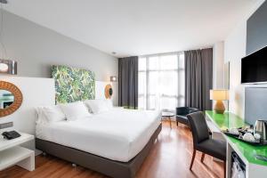 Habitación de hotel con cama y escritorio en Vincci Málaga en Málaga