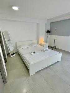 een witte slaapkamer met een wit bed en een lamp bij Sandy Beach Complex in Perivolia