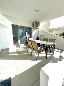 eine Terrasse mit einem Tisch und Stühlen auf einem Haus in der Unterkunft Sandy Beach Complex in Perivolia