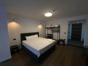 1 dormitorio con 1 cama en una habitación con puerta en HASS Boutique Hotel, en Gostivar