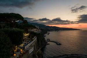 a view of a river at sunset with a city at Grand Hotel Cocumella in Sant'Agnello