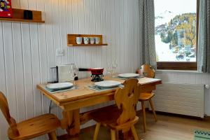 貝特默阿爾卑的住宿－Charming studio, Bettmerhorn view，一张带两把椅子的木桌和一张带酒杯的桌子