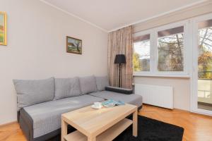 a living room with a couch and a table at Oliwa Forest Apartment with Balcony by Renters in Gdańsk