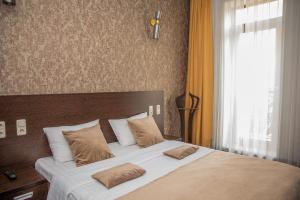 a bed with two pillows on it in a bedroom at Cascade Hotel in Yerevan
