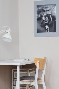 a white desk with a chair and a picture on the wall at Oliwa Forest Apartment with Balcony by Renters in Gdańsk