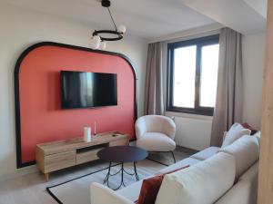 uma sala de estar com um sofá branco e uma parede vermelha em Super Stylish Studio & Bosphorus View in Ortaköy-8 em Istambul