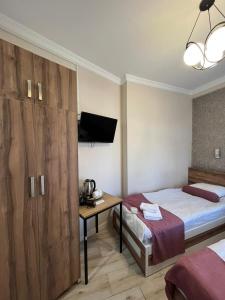 a bedroom with a bed and a desk with a television at MAHALI HOTEL in Batumi