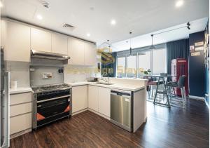 uma grande cozinha com um fogão e uma mesa em 1 Residences Boutique 2 Bed Suite - Parking & Panoramic Views em Dubai