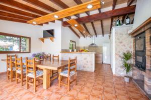 ポリェンサにあるVilla Can Moleto By SunVillas Mallorcaのキッチン、ダイニングルーム(木製のテーブルと椅子付)