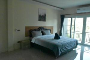 - une chambre avec un lit et un chat assis dans l'établissement Triple J Hometel, à Bang Tao Beach