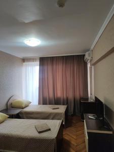 a hotel room with two beds and a television at Hotel Prietenia in Bender