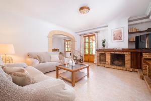 sala de estar con sofá y chimenea en Villa Can Moleto By SunVillas Mallorca, en Pollensa