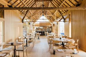 a restaurant with wooden ceilings and tables and chairs at Hopspot in Evergem