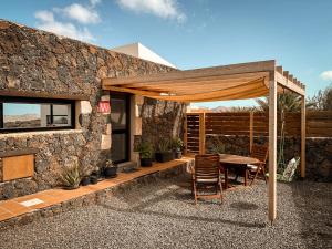 patio ze stołem i krzesłami pod baldachimem w obiekcie CASA LA BOCAINA - private villa with panorama & ocean view w mieście Villaverde